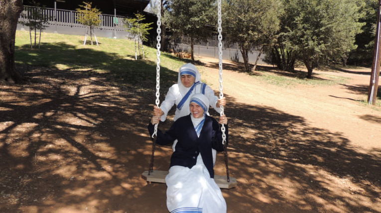 Nuns having fun on tree swing