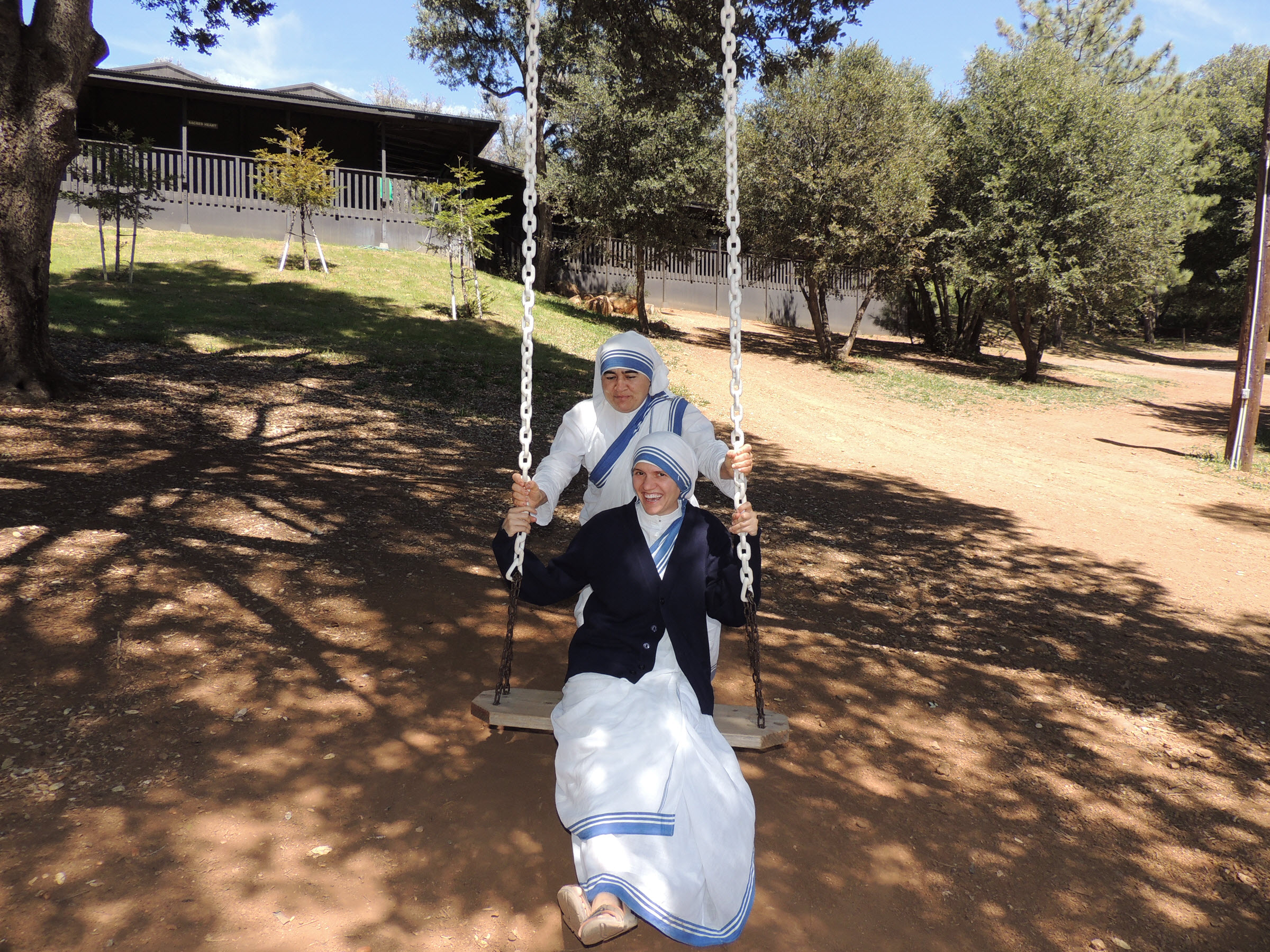 Nuns having fun on tree swing