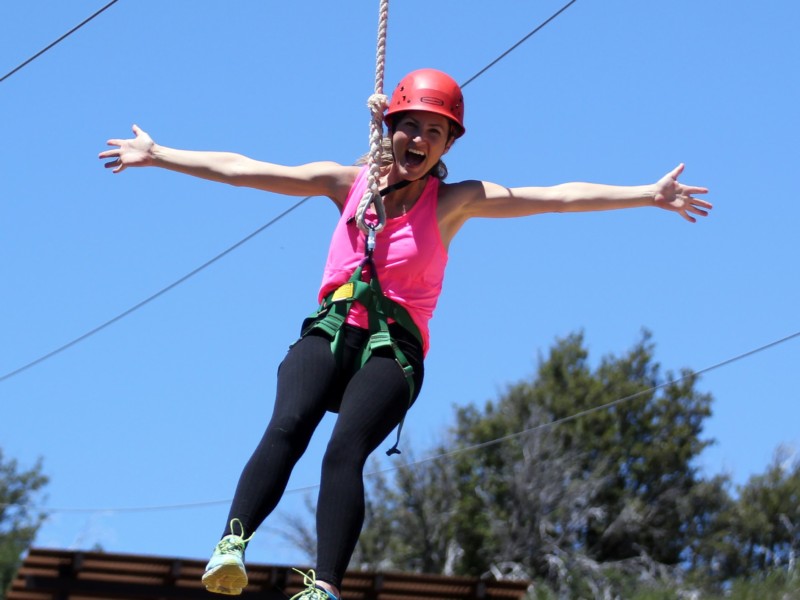 Woman on zipline celebrating with arms wide
