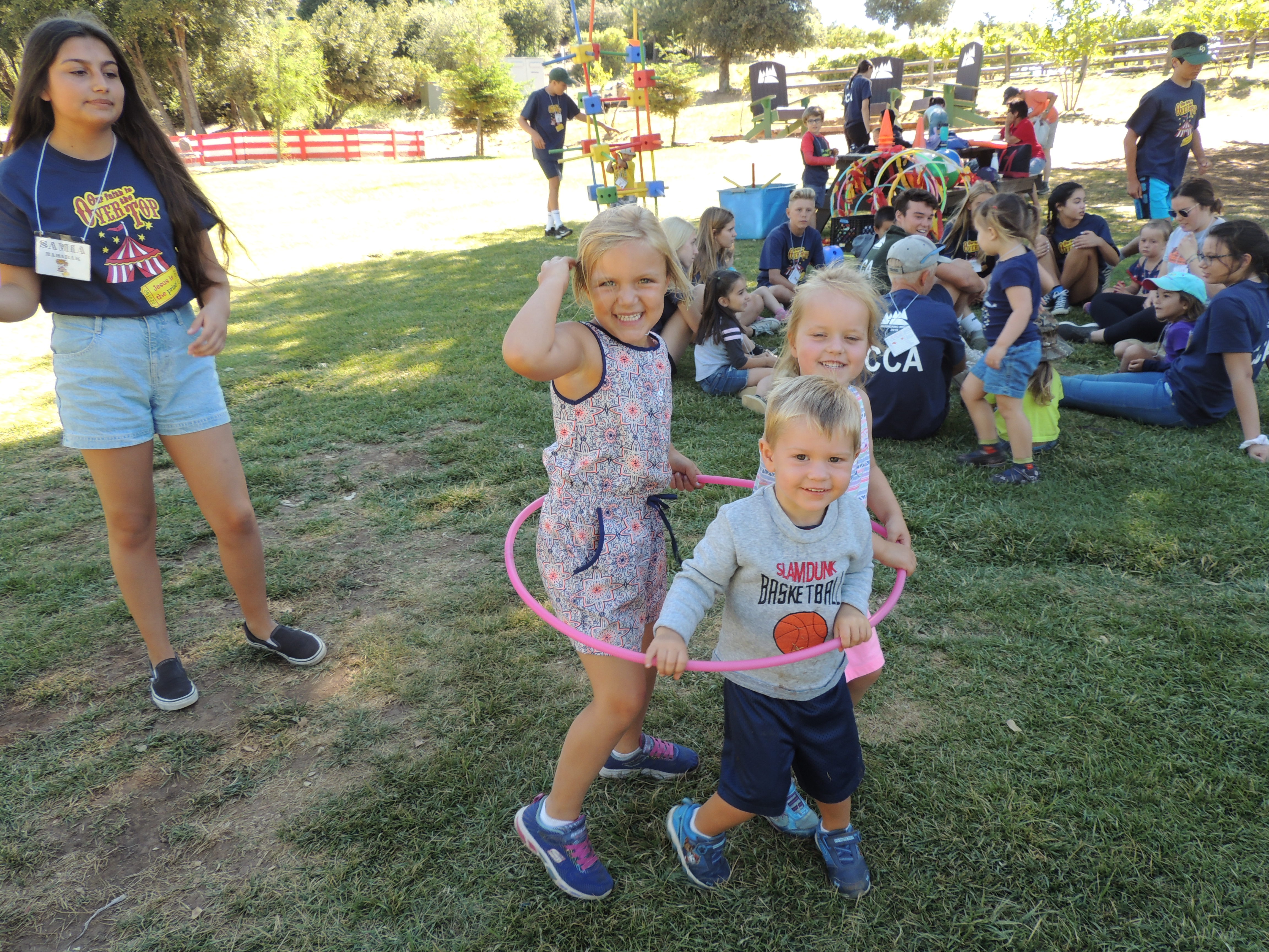 Group of three children in hula hoop on meadow during Family Camp