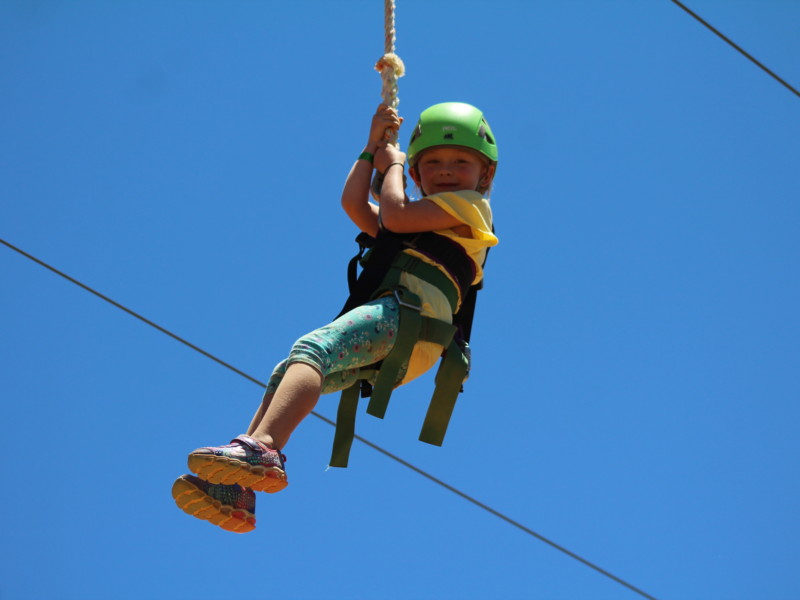 Young girl on zipline during family Camp