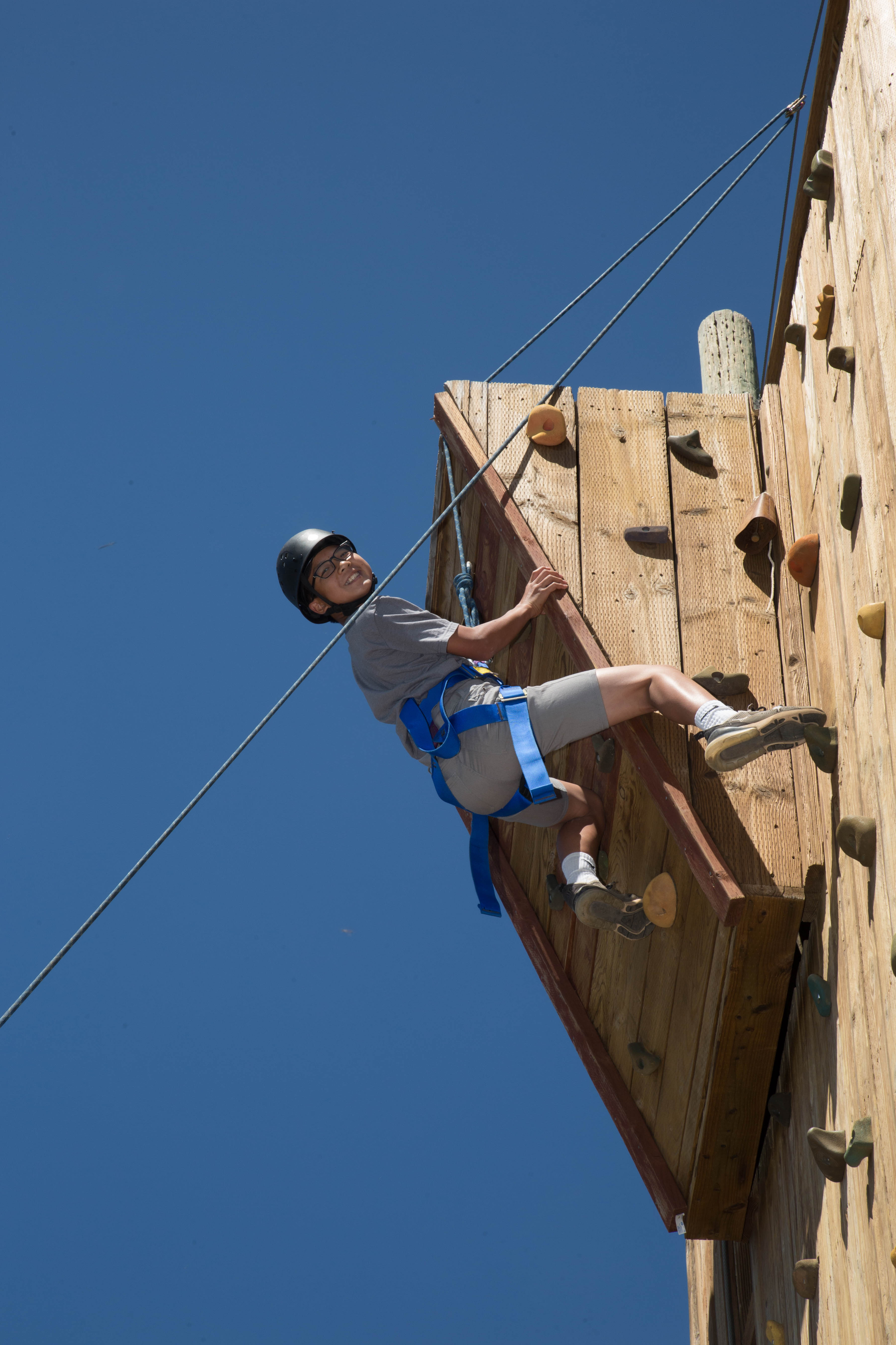 Teen at top of climbing wall