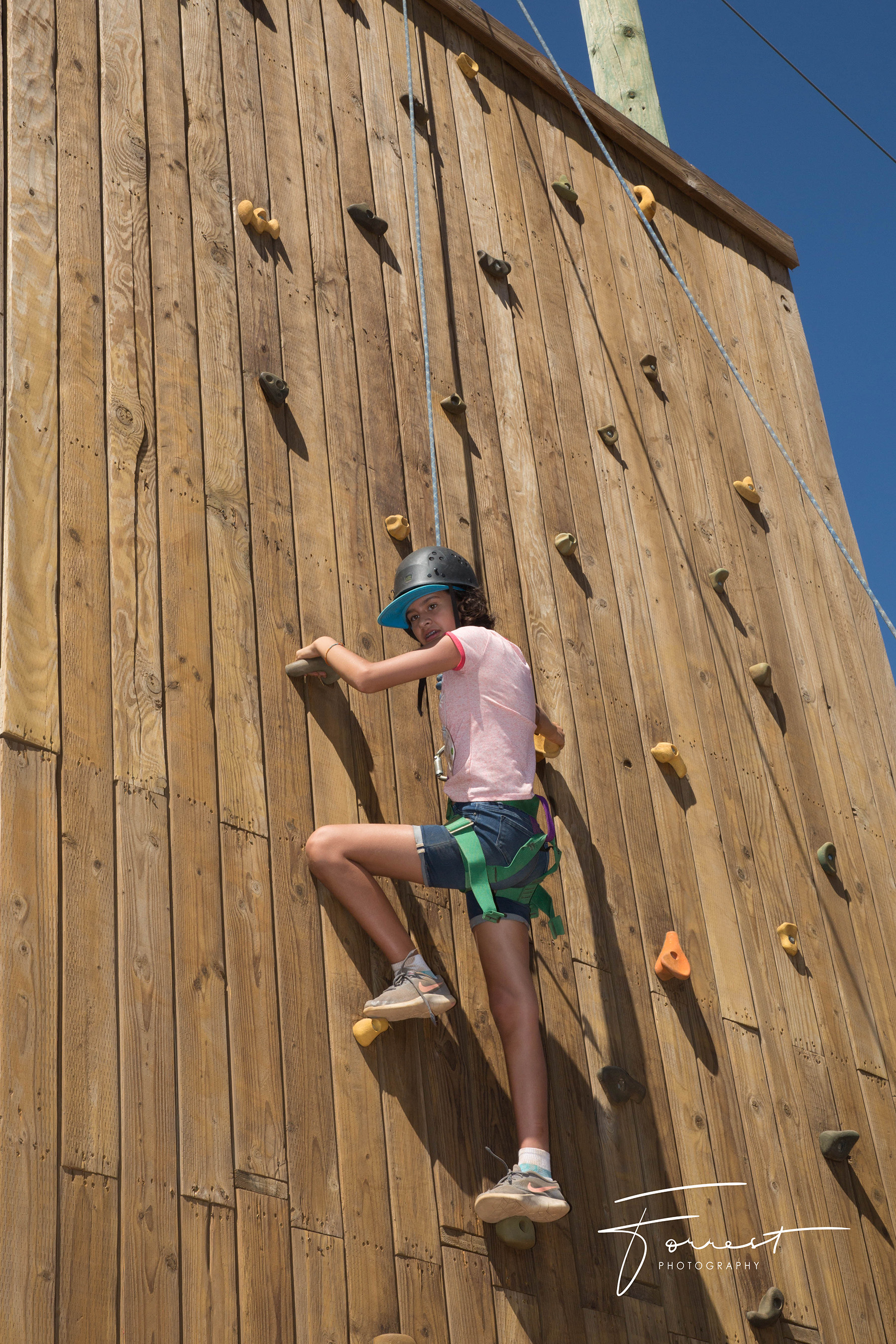 Girl on climbing wall during Family Camp