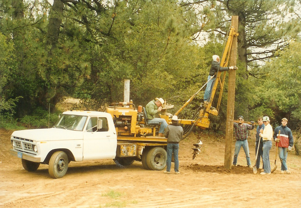 1978 construction work party with truck-mounted post hole digger