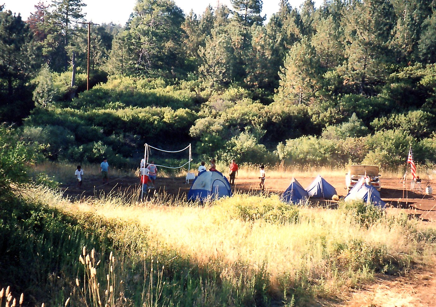 Tents near volleyball net with players form 1978