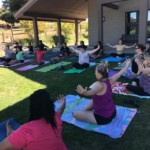 Adult women on grass doing yoga pose