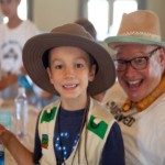 Women's Auxiliary volunteer helping a boy during family camp crafts