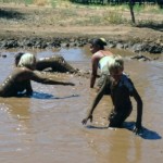 People splashing around in mud pit during Family Camp