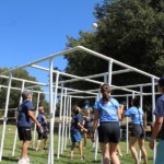 Young adults playing 9 square on meadow