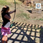 Aiming bow and arrow at archery target